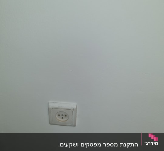 שקע חשמל בקיר לבן